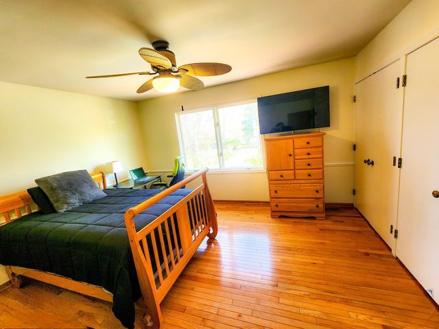 bedroom with light wood-type flooring and ceiling fan