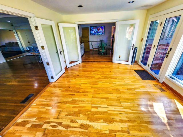 hall with french doors, light wood-style flooring, and visible vents