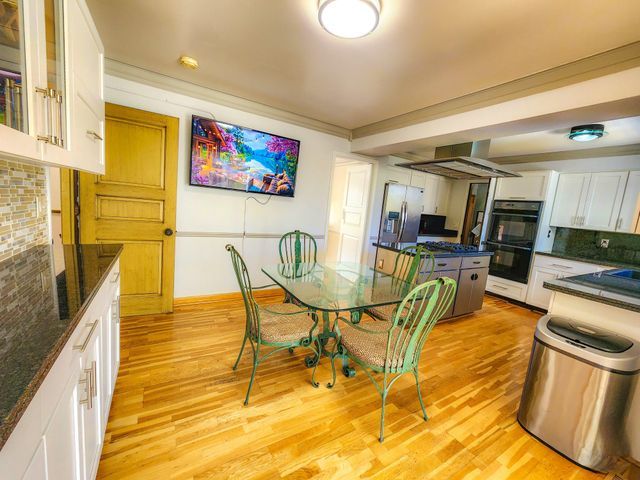 dining space featuring baseboards, ornamental molding, and light wood-style flooring
