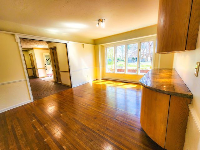 unfurnished room with wood-type flooring and baseboards