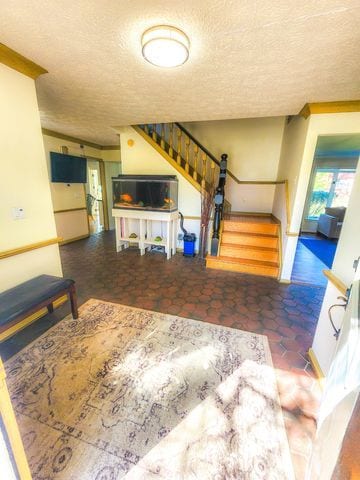 living area with a textured ceiling and stairway