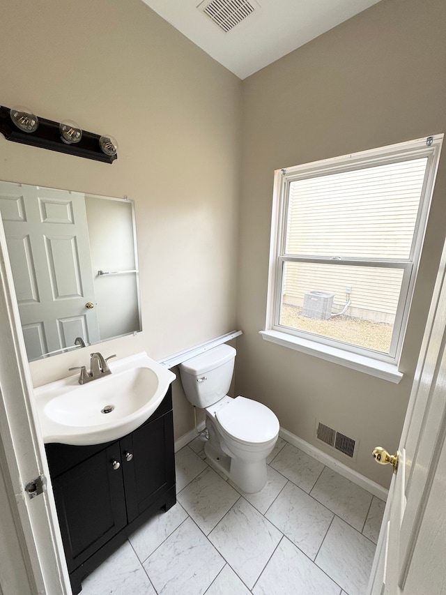 bathroom with vanity, toilet, visible vents, and marble finish floor