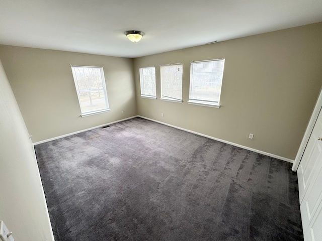 unfurnished bedroom with baseboards and dark colored carpet