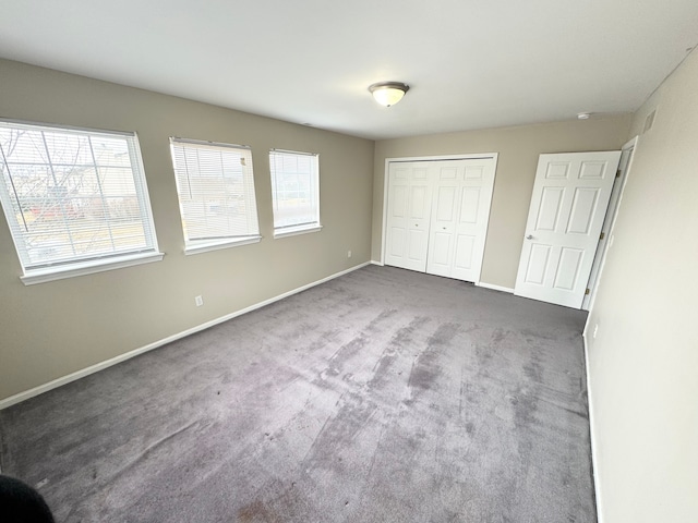 unfurnished bedroom with a closet, baseboards, and carpet floors