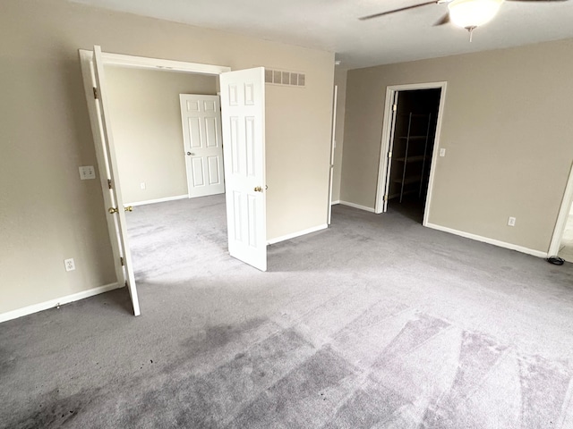 unfurnished room featuring visible vents, carpet flooring, baseboards, and ceiling fan