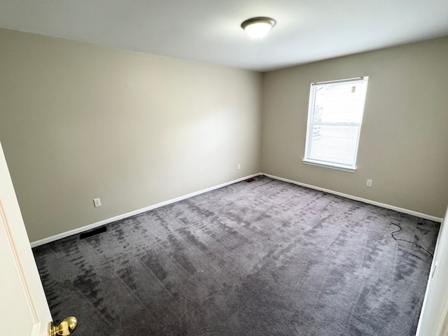 carpeted spare room featuring baseboards