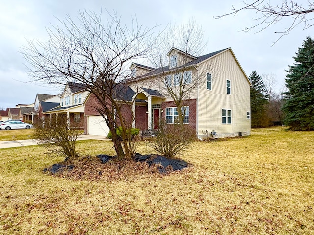 view of front facade with driveway, brick siding, and a front yard