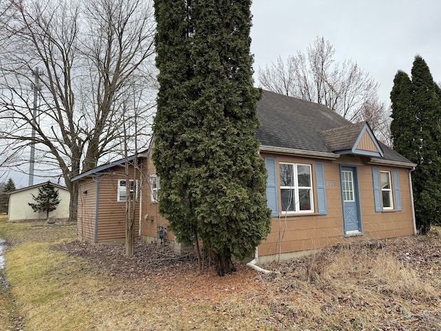 view of property exterior with a shingled roof