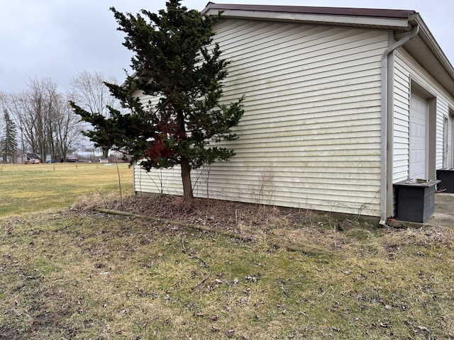 view of side of property with a lawn and a garage