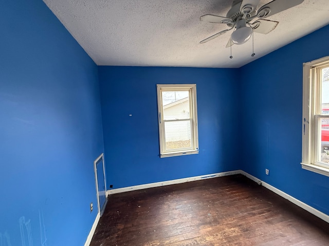 unfurnished room featuring a textured ceiling, wood finished floors, baseboards, and ceiling fan