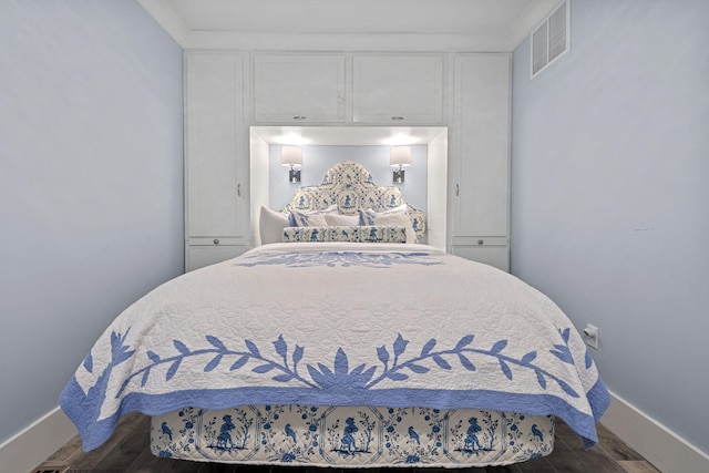 bedroom featuring visible vents, baseboards, and wood finished floors