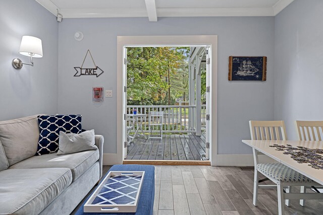 living area featuring wood finished floors, baseboards, a wealth of natural light, and ornamental molding