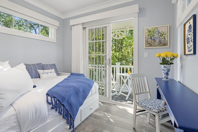 bedroom featuring access to exterior, crown molding, and wood finished floors