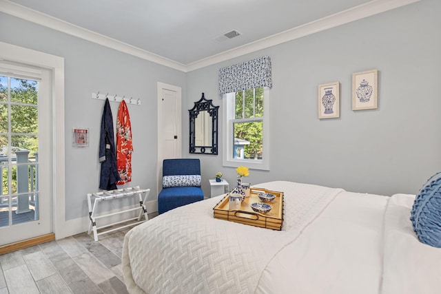 bedroom with visible vents, crown molding, baseboards, wood finished floors, and access to outside