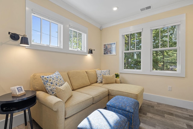 living area with wood finished floors, baseboards, visible vents, recessed lighting, and ornamental molding