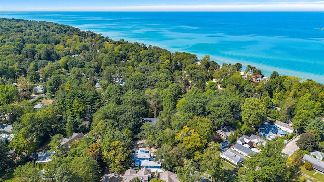 drone / aerial view with a wooded view and a water view