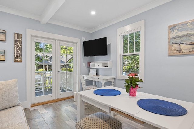 dining area featuring wood finished floors, beamed ceiling, a healthy amount of sunlight, and crown molding