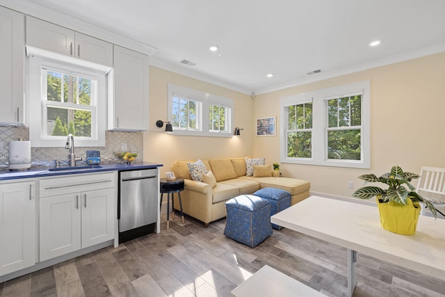 living room featuring crown molding, recessed lighting, visible vents, and light wood-type flooring