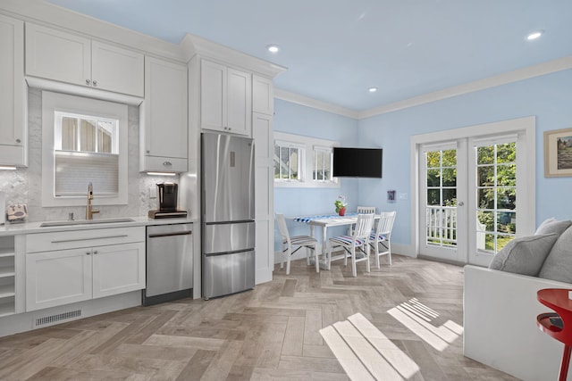 kitchen with visible vents, a sink, light countertops, appliances with stainless steel finishes, and tasteful backsplash