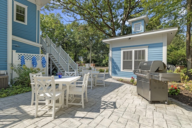 view of patio / terrace featuring stairs, central air condition unit, area for grilling, and outdoor dining area