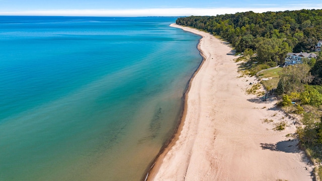 birds eye view of property with a water view and a beach view