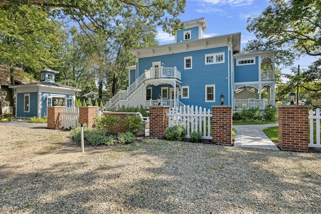 italianate house with a fenced front yard and a balcony