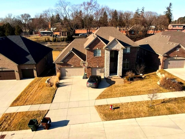 traditional home featuring brick siding, an attached garage, and driveway