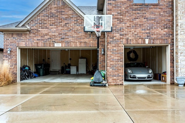 garage with driveway and freestanding refrigerator