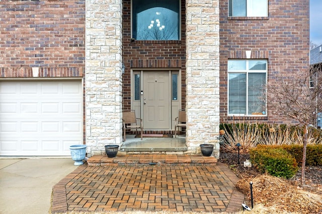 entrance to property with brick siding and a garage