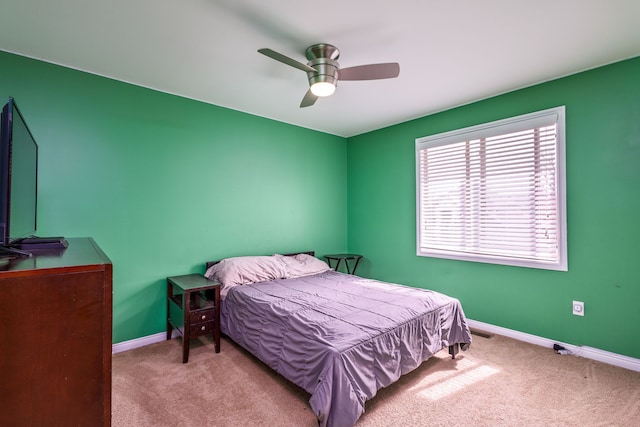 bedroom with a ceiling fan, baseboards, and carpet floors