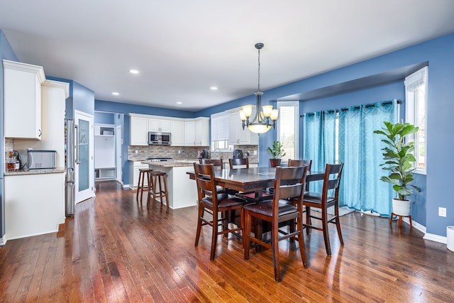 dining room with dark wood finished floors, an inviting chandelier, baseboards, and recessed lighting