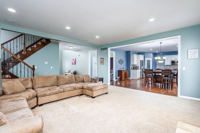 living area with dark colored carpet, recessed lighting, and a chandelier