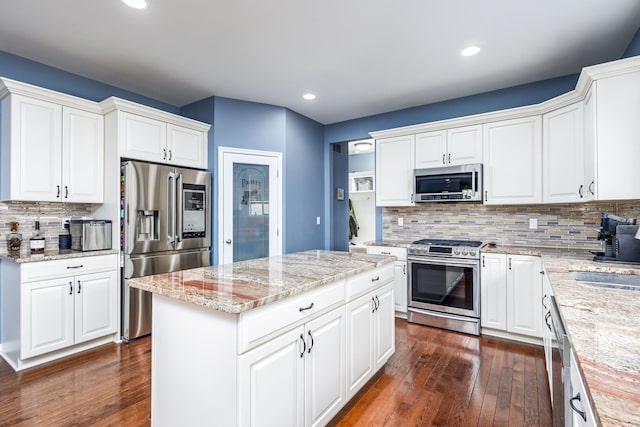 kitchen featuring backsplash, dark wood-style flooring, stainless steel appliances, and a sink