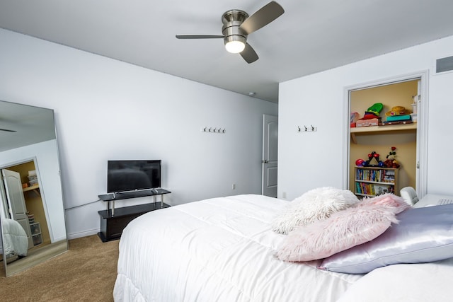 carpeted bedroom featuring a ceiling fan, visible vents, and a walk in closet