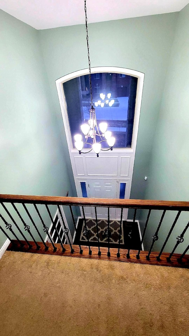 staircase with carpet, baseboards, and an inviting chandelier