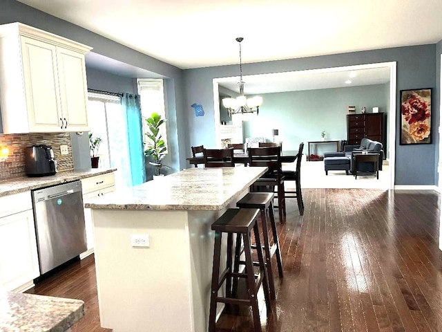kitchen featuring a kitchen breakfast bar, dishwasher, backsplash, a notable chandelier, and dark wood-type flooring