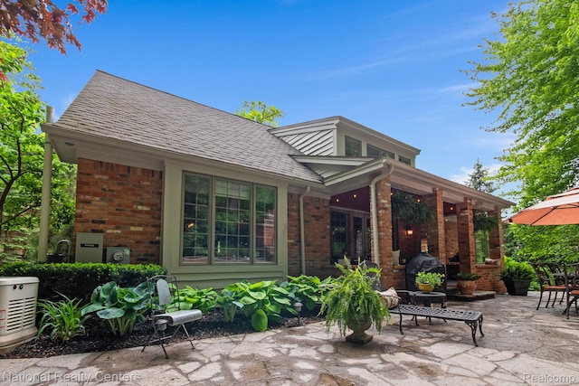 6654 College Park, Clarkston, MI 48346 - rear view of house with brick siding, a patio area, and roof with shingles