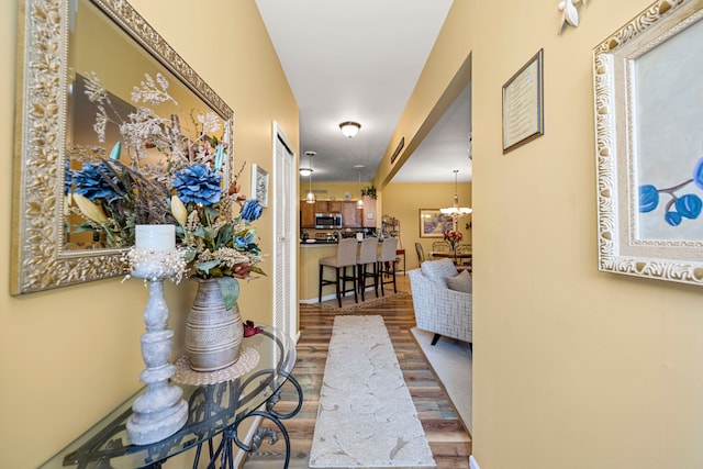 hall with a chandelier and wood finished floors