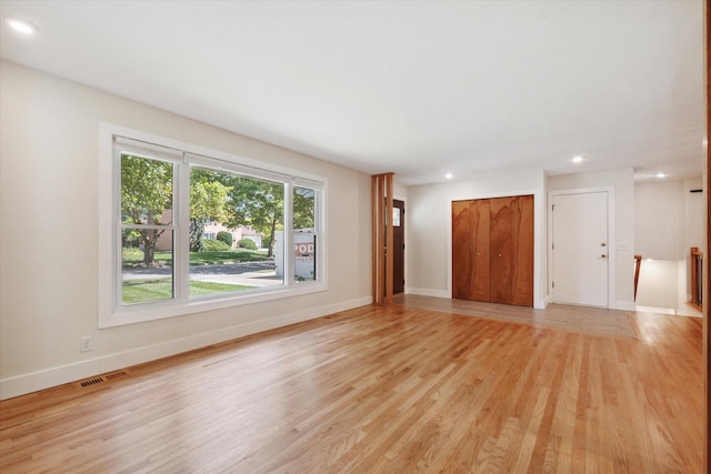 unfurnished living room with recessed lighting, light wood-style floors, visible vents, and baseboards