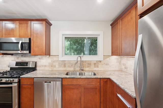 kitchen with a sink, stainless steel appliances, and brown cabinetry