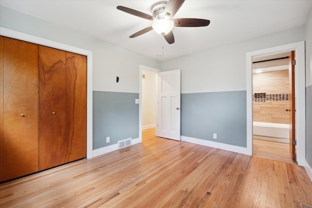 unfurnished bedroom featuring a closet, visible vents, light wood-style flooring, and baseboards