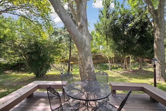 deck featuring outdoor dining space, a yard, and fence