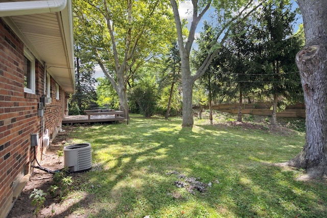 view of yard with a deck and central AC unit