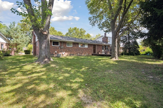 exterior space featuring a lawn, brick siding, and a chimney