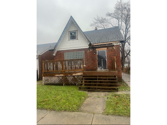 view of front of house with brick siding, roof with shingles, and a wooden deck