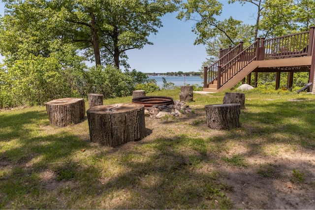 7107 Hallenbeck Hwy, Manitou Beach, MI 49253 - view of green lawn with stairway, an outdoor fire pit, and a deck with water view