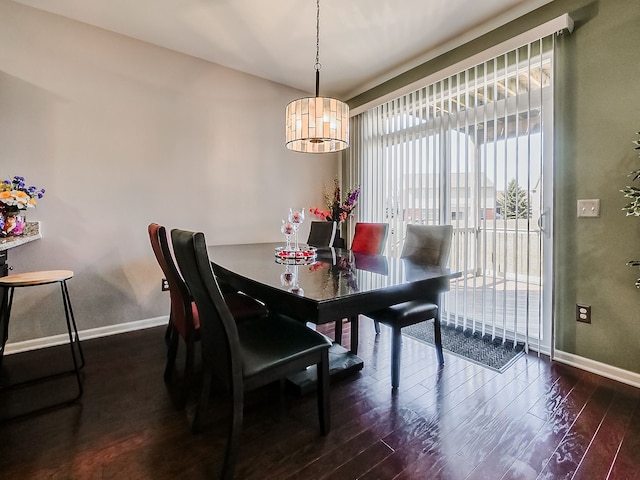 dining room featuring a notable chandelier, baseboards, and dark wood-style flooring