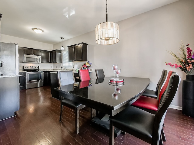 dining space with dark wood finished floors and baseboards