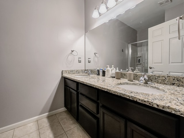 full bath featuring tile patterned floors, baseboards, a stall shower, and a sink