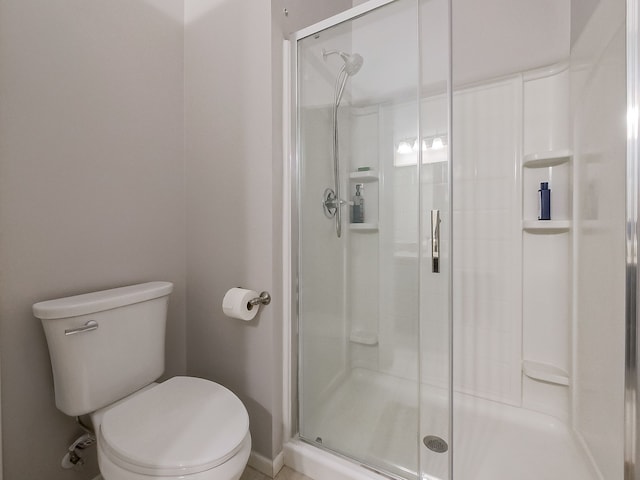 full bath featuring a stall shower and toilet